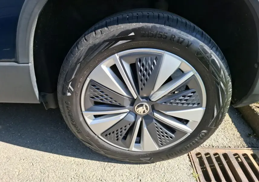 Gros plan sur la roue avant droite d’un Skoda Karoq bleu avec jante alu 17 pouces au design moderne.