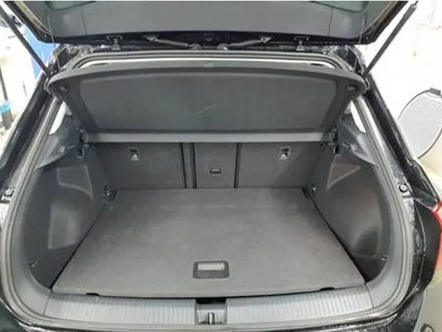 Coffre ouvert vu de l'arrière d'un Volkswagen T-Roc gris foncé 2025, montrant un espace de chargement spacieux et propre.