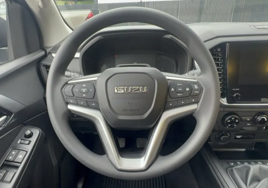 Vue centrée sur le volant multifonctions noir d’un Isuzu D-MAX 2026 avec tableau de bord et écran tactile.