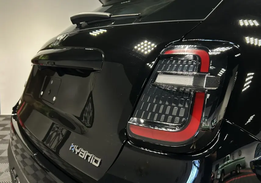 Vue 3/4 arrière droite d'une FIAT 600 noire avec feux arrière LED et logo Hybrid sur le hayon.