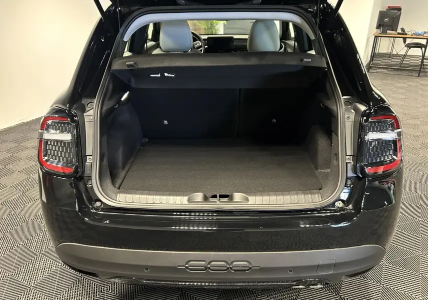 Vue arrière du coffre ouvert de la FIAT 600 noire, mettant en valeur les feux arrière LED et l’espace de chargement vide.