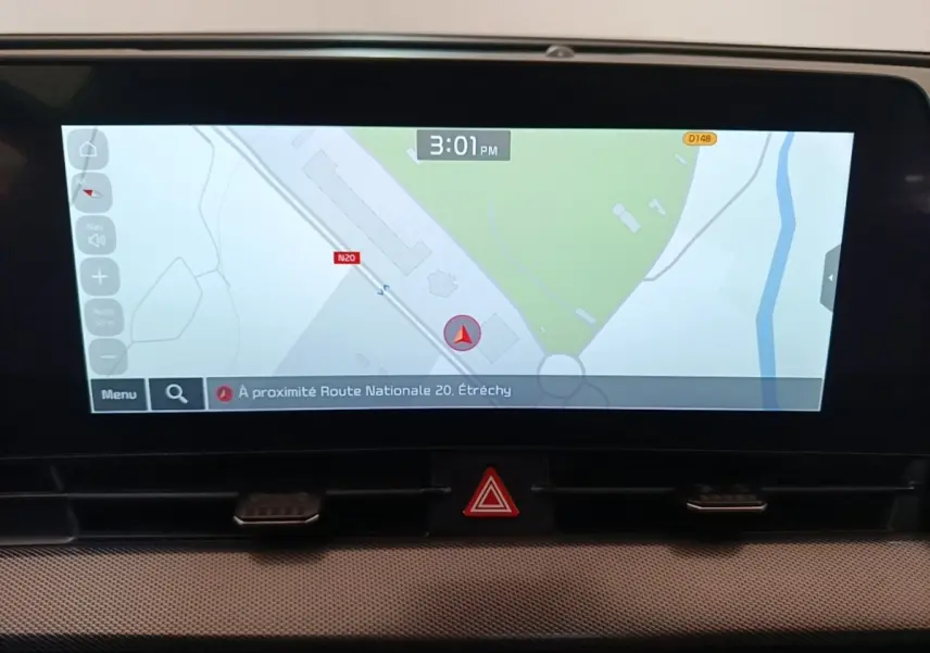 Écran tactile central du tableau de bord du Kia Sportage gris clair, affichant la navigation GPS en plein jour.