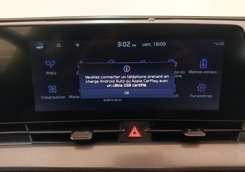 Écran tactile central du tableau de bord du Kia Sportage gris clair, affichant un message de connexion Android Auto/Apple CarPlay.