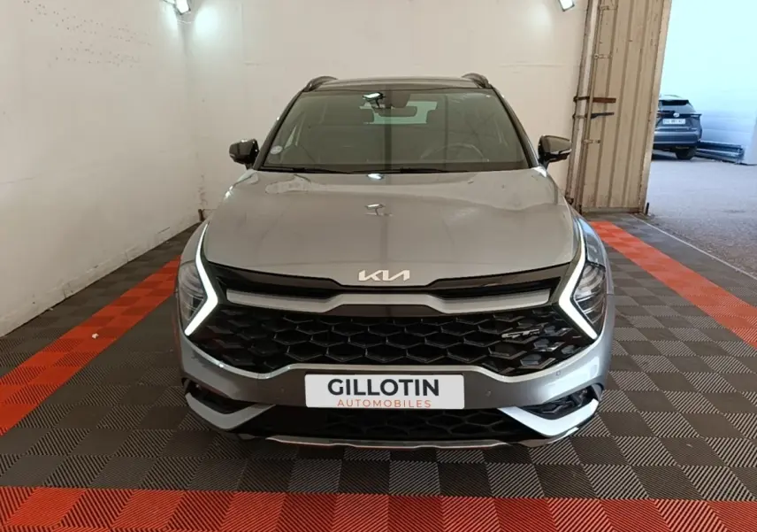 Vue avant d'un KIA Sportage gris clair avec éclairage LED en forme de C et calandre noire hexagonale.
