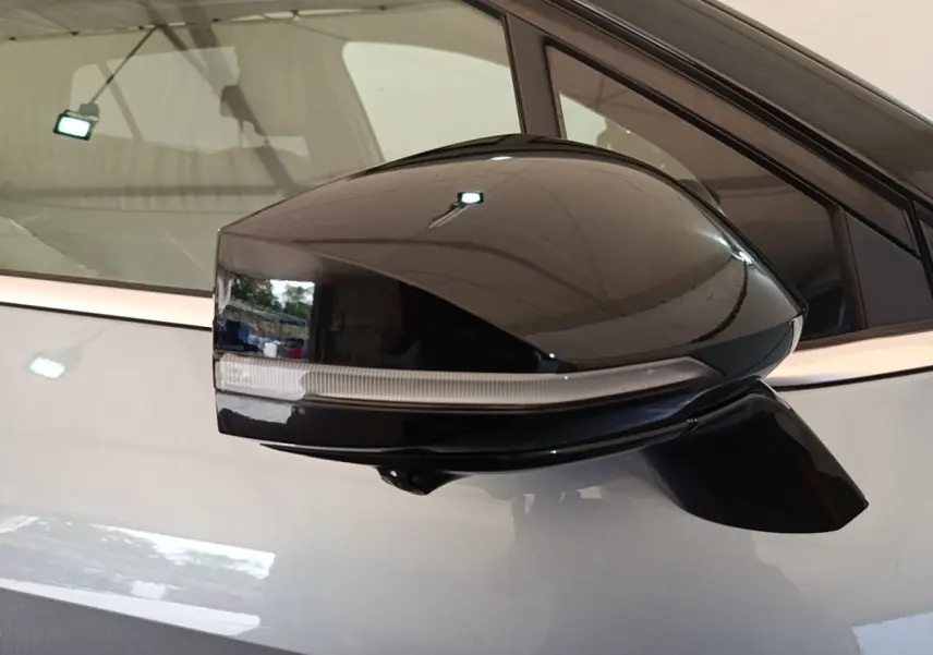 Rétroviseur noir en gros plan sur le côté gauche d’un KIA Sportage gris clair hybride rechargeable 2022.
