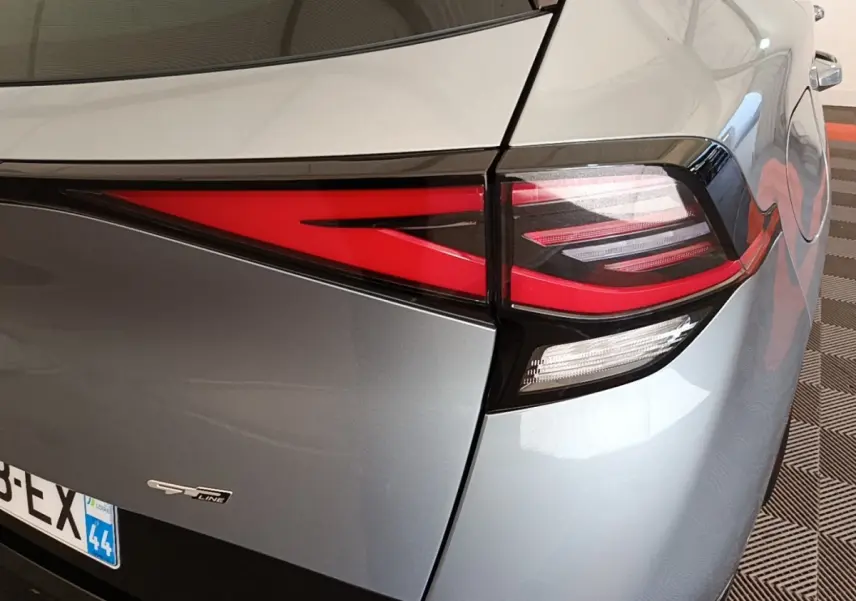 Gros plan sur le feu arrière droit rouge et blanc d’un KIA Sportage gris clair version GT-Line.