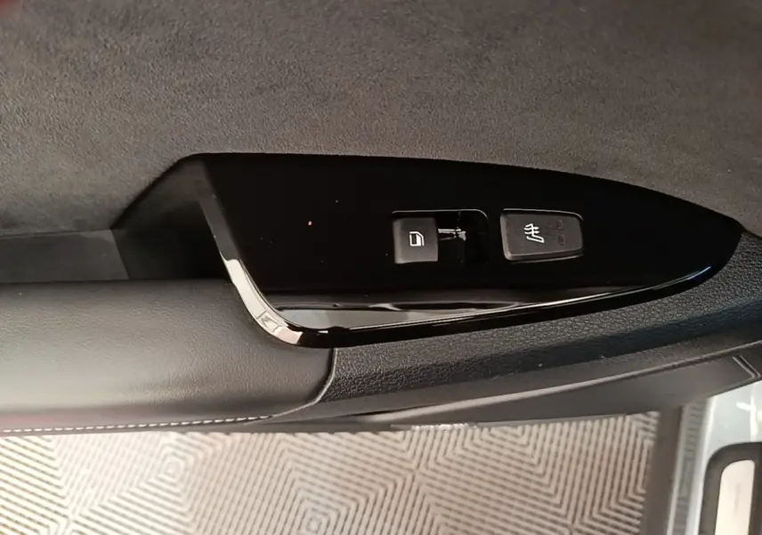 Détail des commandes de verrouillage et dégivrage sur la porte intérieure côté conducteur d’un Kia Sportage gris clair 2022.