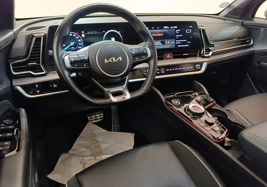 Vue intérieure côté conducteur du tableau de bord noir et volant cuir du KIA Sportage hybride rechargeable 2022.