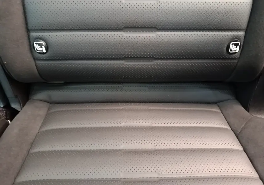 Gros plan sur la banquette arrière en cuir perforé gris foncé du Kia Sportage 2022, avec logos Isofix visibles.