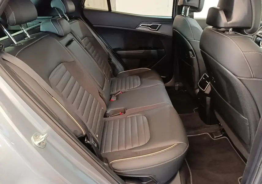 Vue côté gauche des sièges arrière en cuir noir avec surpiqûres blanches d'un KIA Sportage gris clair 2022.