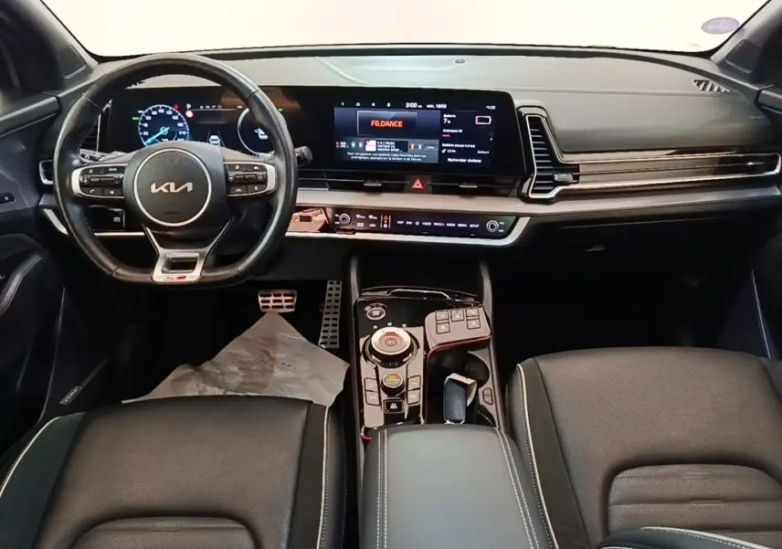Vue intérieure du tableau de bord et volant noir du Kia Sportage 2022 avec écran tactile large et console centrale moderne.