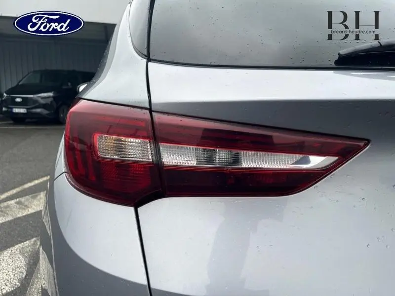 Gros plan sur le feu arrière gauche d'un Opel Grandland X gris Quartz avec toit et rétroviseurs noirs.