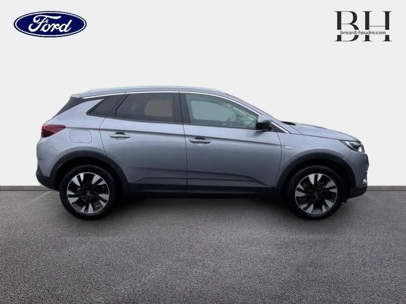 Opel Grandland X 1.5 D 130ch Elite 2020 en profil droit gris quartz avec toit et rétros noirs.