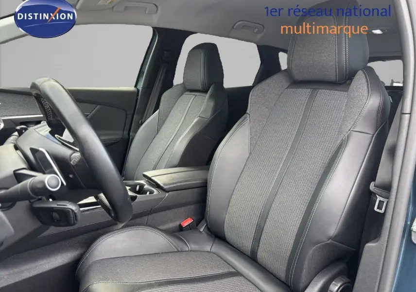 Vue intérieure côté conducteur du Peugeot 3008 hybride 2022, sièges en cuir et tissu gris avec surpiqûres contrastées.