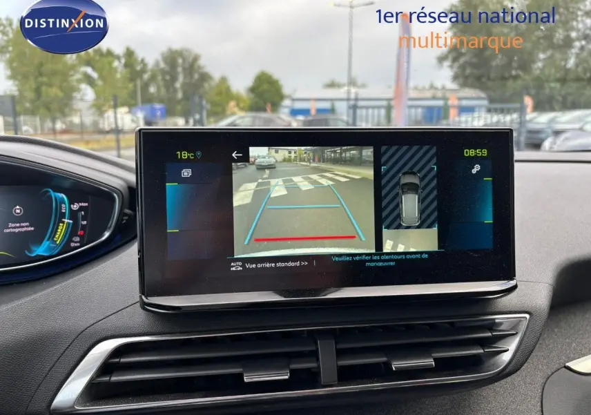 Vue intérieure du tableau de bord du Peugeot 3008 hybride 2022, écran affichant la caméra de recul et les aides au stationnement.
