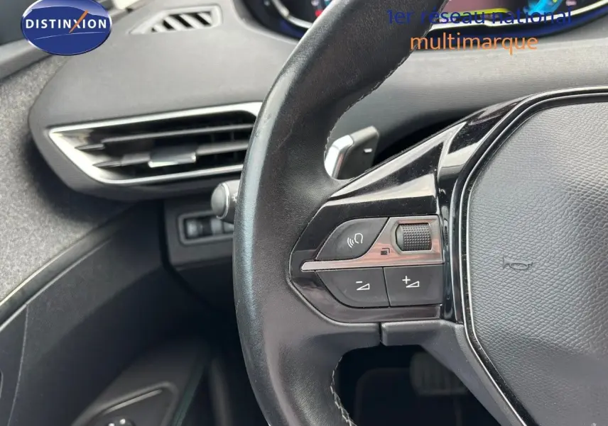 Gros plan sur le volant noir et la partie gauche du tableau de bord du Peugeot 3008 bleu Celebes Hybrid 2022.