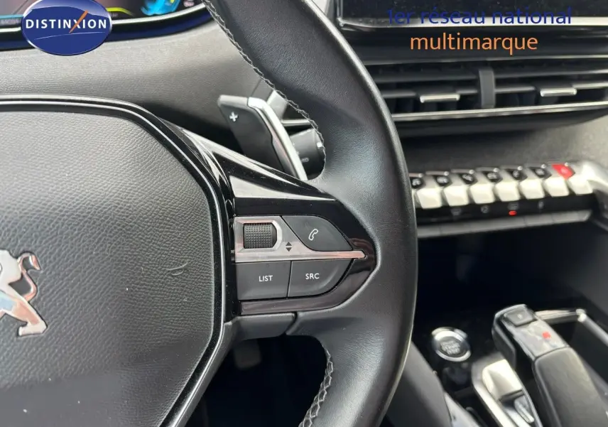 Gros plan sur le volant et la console centrale du Peugeot 3008 hybride, mettant en valeur les commandes intégrées et le levier de vitesse.