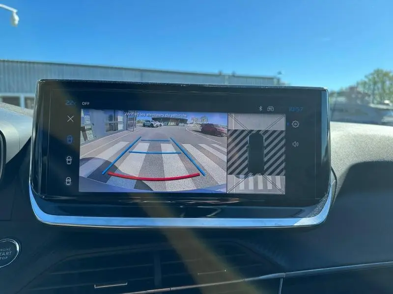 Écran central du Peugeot 2008 Hybrid 2025 montrant la caméra de recul avec guidage de trajectoire en bleu et rouge.