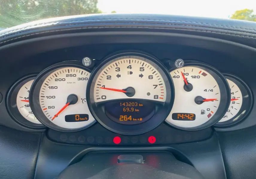 Tableau de bord de Porsche 911 Targa 996 gris foncé, affichage des compteurs et kilométrage à 143203 km.