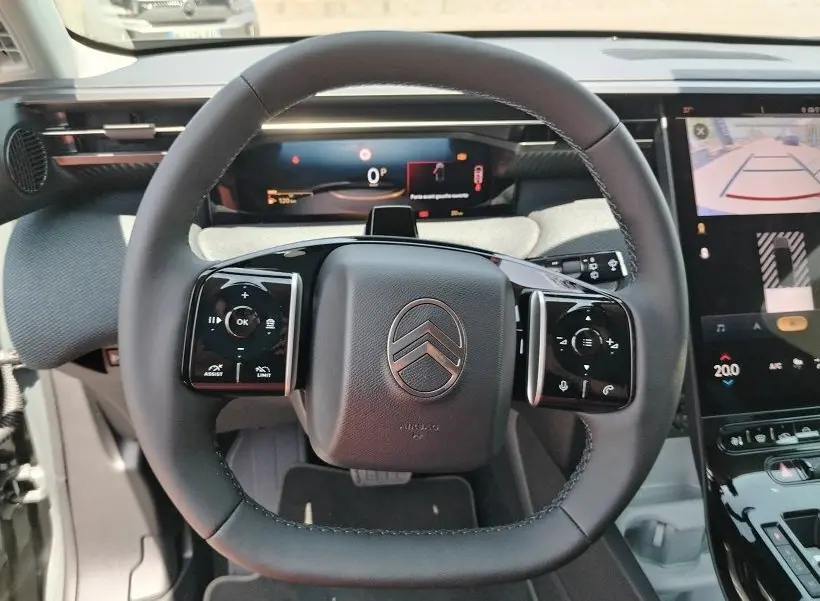 Vue rapprochée du volant noir du Citroën C5 Aircross 2026 avec affichage numérique et écran tactile à droite.