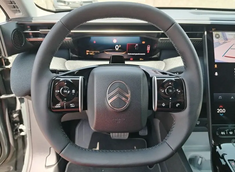Vue intérieure centrée sur le volant du Citroën C5 Aircross 2026, avec commandes intégrées et tableau de bord numérique.