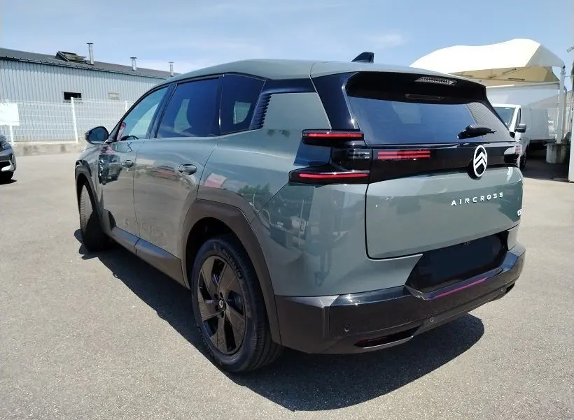 Vue 3/4 arrière droite d’un Citroën C5 Aircross 2026 Vert Astoria avec feux arrière horizontaux et toit noir.