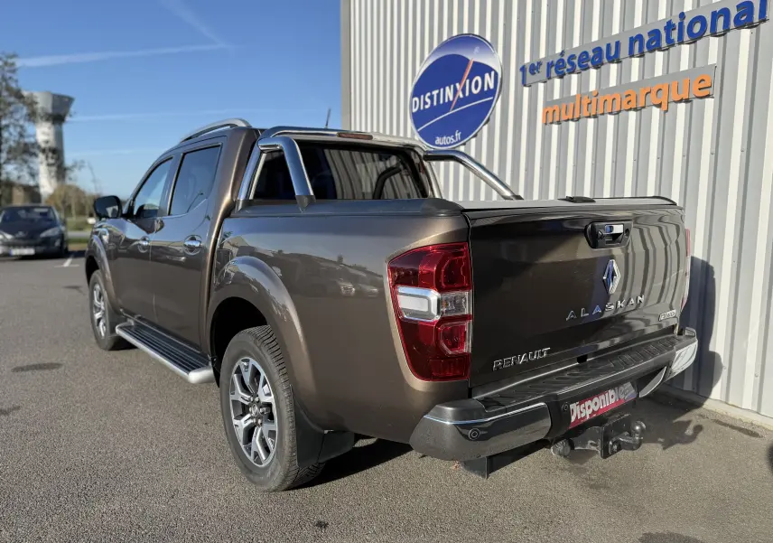 Vue 3/4 arrière droite d'un Renault Alaskan brun 2018 avec barre de protection et attelage visible.