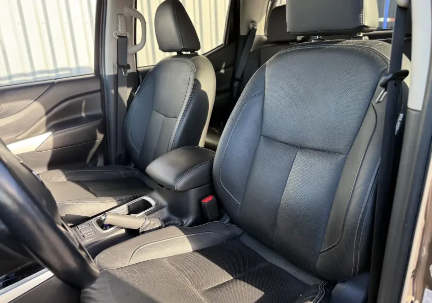 Intérieur du Renault Alaskan 2018 en cuir noir, vue côté conducteur montrant les sièges avant et accoudoir central.