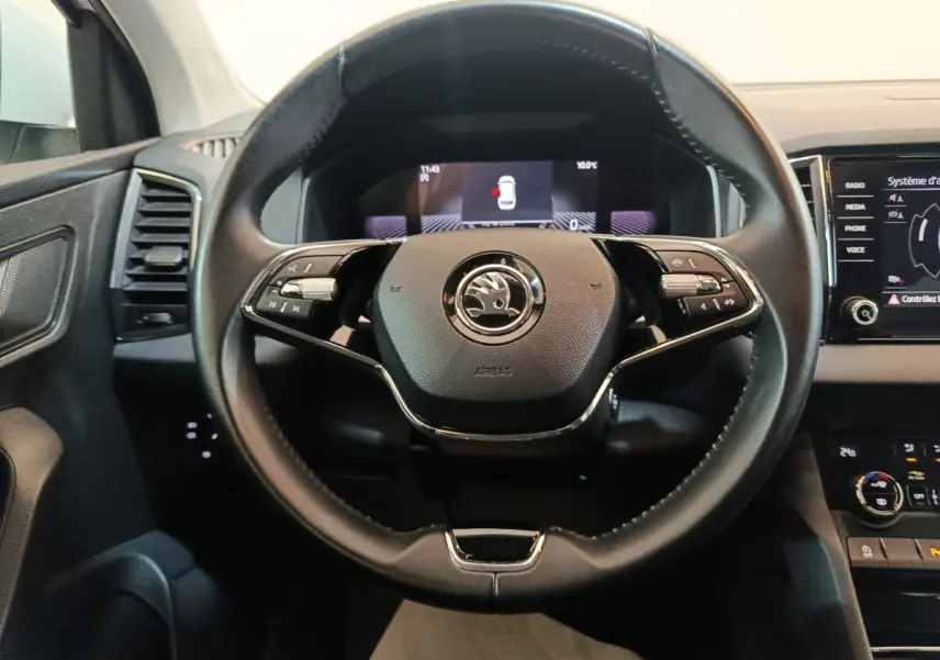 Vue rapprochée du volant cuir noir du Skoda Karoq 2024 avec commandes multifonctions et tableau de bord digital.