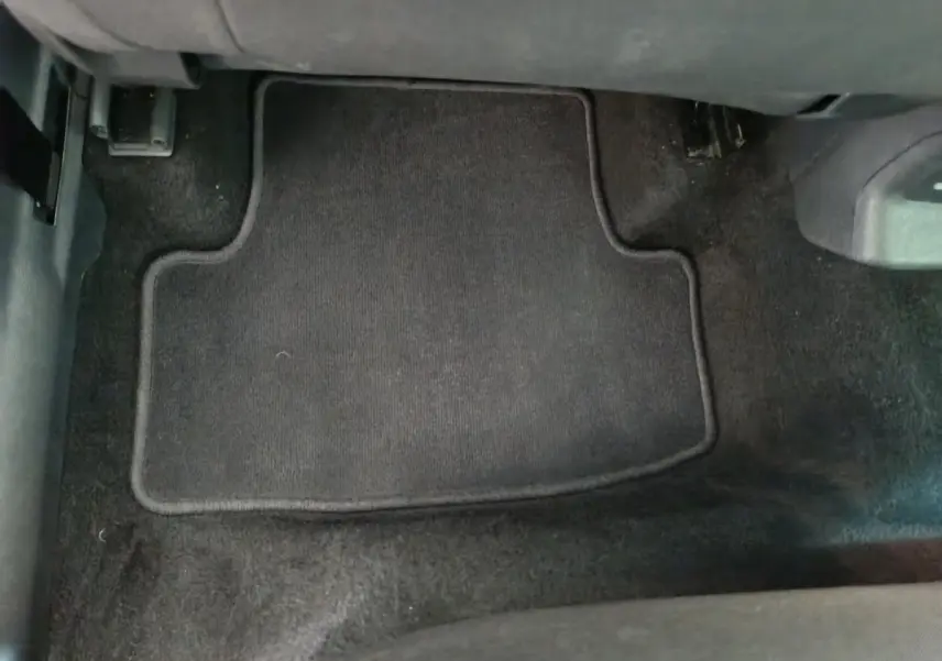 Vue rapprochée du tapis de sol noir côté conducteur du Skoda Karoq blanc 2024, version 2.0 TDI Selection.