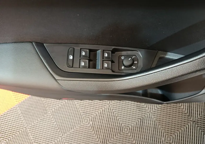 Panneau de commandes des vitres et rétroviseurs côté conducteur d’un Skoda Karoq blanc 2024, intérieur noir.