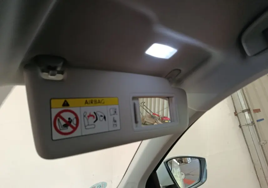 Miroir de courtoisie ouvert sur pare-soleil côté conducteur dans Skoda Karoq blanc, vue intérieure avant droite.
