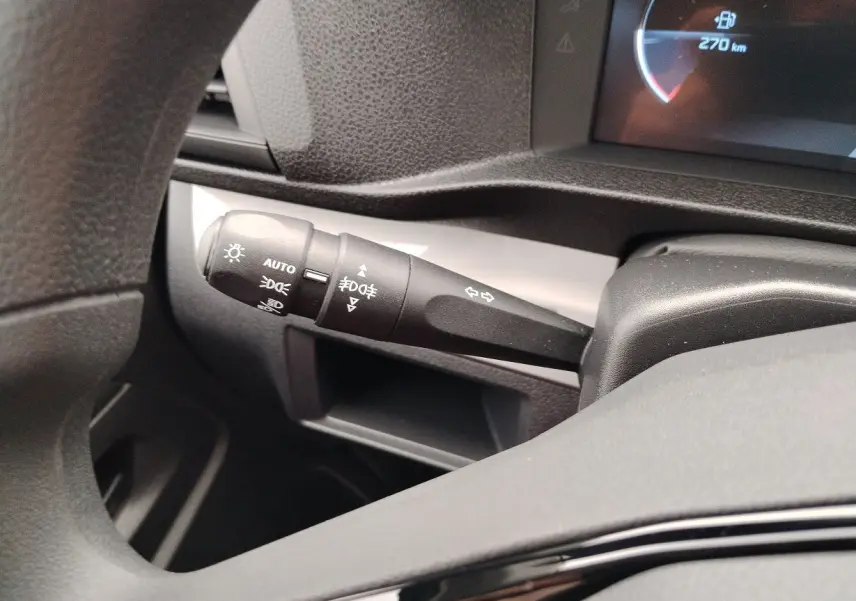 Gros plan sur la commande des feux et clignotants à gauche du volant dans le tableau de bord gris du Peugeot Expert Cabine Approfondie 2025.