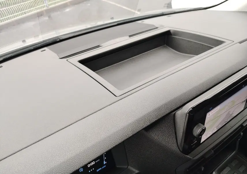 Vue rapprochée du tableau de bord noir du Peugeot Expert Cabine Approfondie 2025 avec écran tactile et rangement intégré.