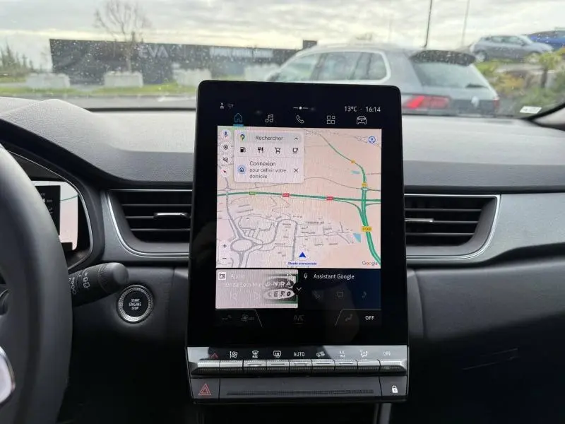 Vue intérieure du tableau de bord du Renault Captur 2025, avec écran tactile central affichant une carte de navigation.