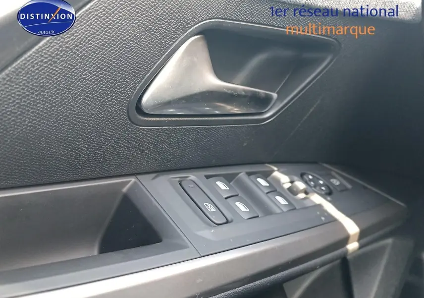 Gros plan sur la commande des vitres et la poignée intérieure côté conducteur d’une Peugeot 3008 bleu 2025.