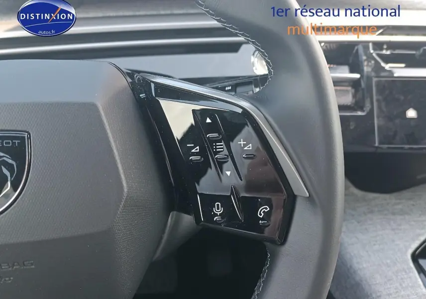 Gros plan sur le volant cuir noir du Peugeot 3008 2025 avec commandes multifonctions et tableau de bord tactile en arrière-plan.