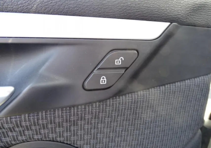 Détail des boutons de verrouillage sur la portière intérieure côté conducteur du BMW X1 blanc 2017.