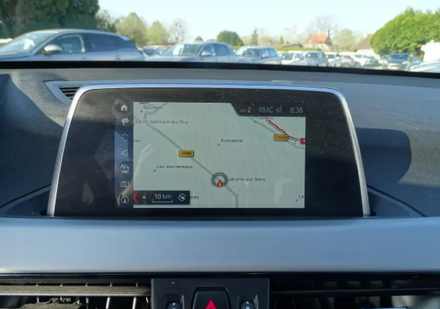 Vue intérieure centrée sur l'écran de navigation du tableau de bord d'une BMW X1 Business Design 2017.