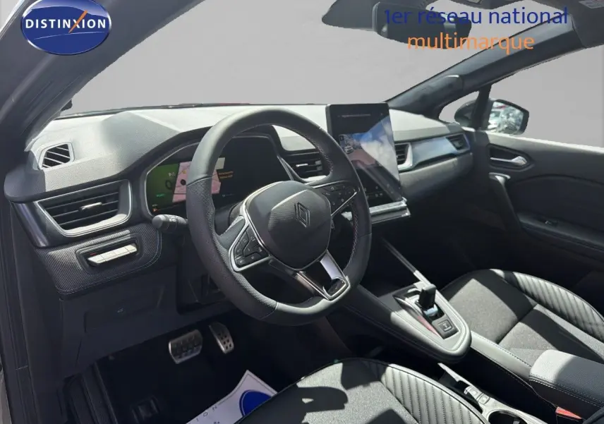 Vue intérieure côté conducteur de la Renault Symbioz gris cassiopée, volant cuir et écran tactile vertical lumineux.