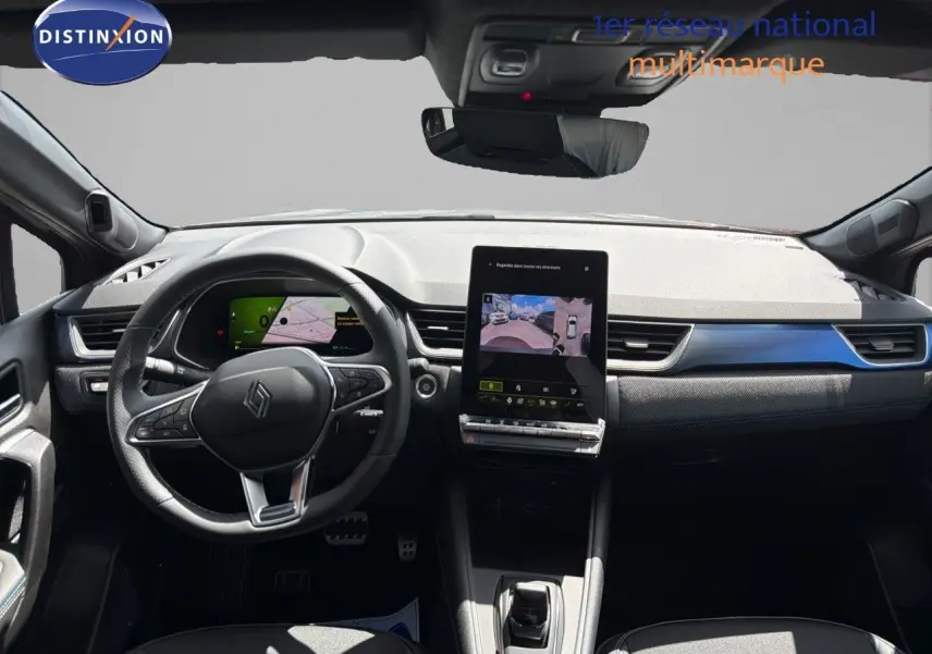Vue intérieure avant du tableau de bord de la Renault Symbioz gris cassiopée, avec écran tactile central et volant multifonction.