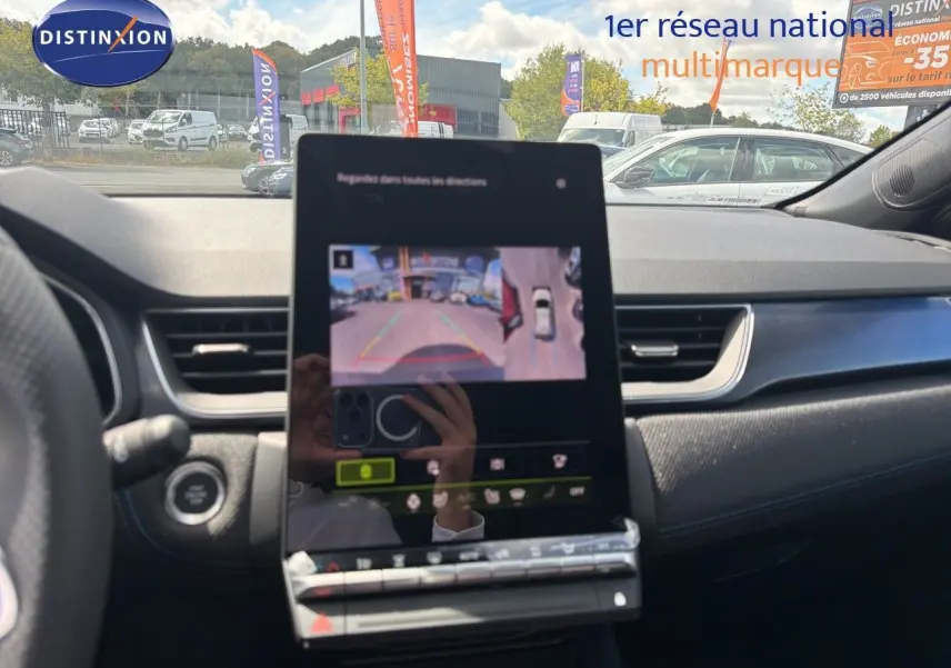 Vue intérieure du tableau de bord de la Renault Symbioz gris cassiopée, avec écran tactile affichant la caméra de recul.