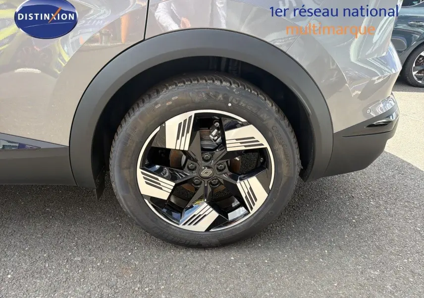 Gros plan sur la roue arrière droite du Renault Symbioz gris Cassiopée métal avec jante noire et argentée au design moderne.
