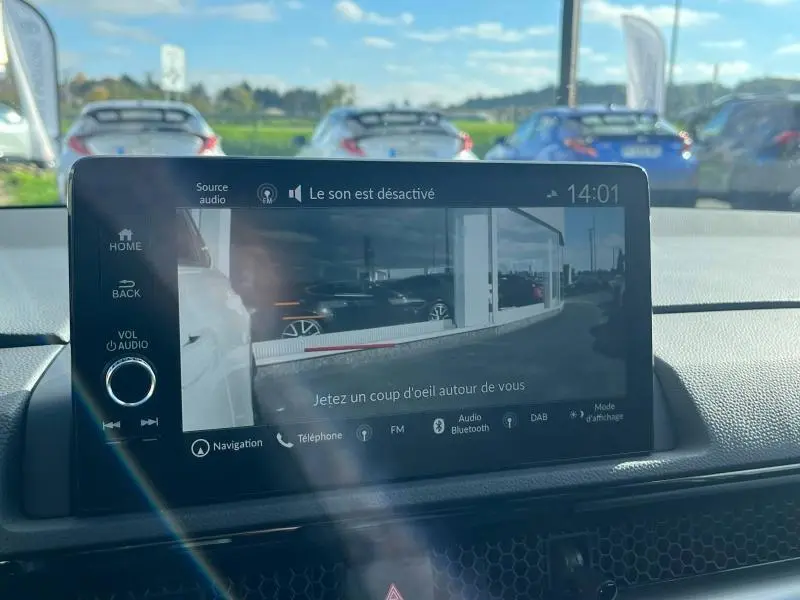 Écran tactile central du Honda CR-V 2024 montrant la caméra de recul avec vue arrière extérieure en journée.