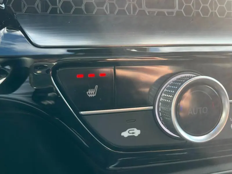 Gros plan sur la commande de chauffage de siège avec trois voyants rouges dans l'habitacle du Honda CR-V 2024.