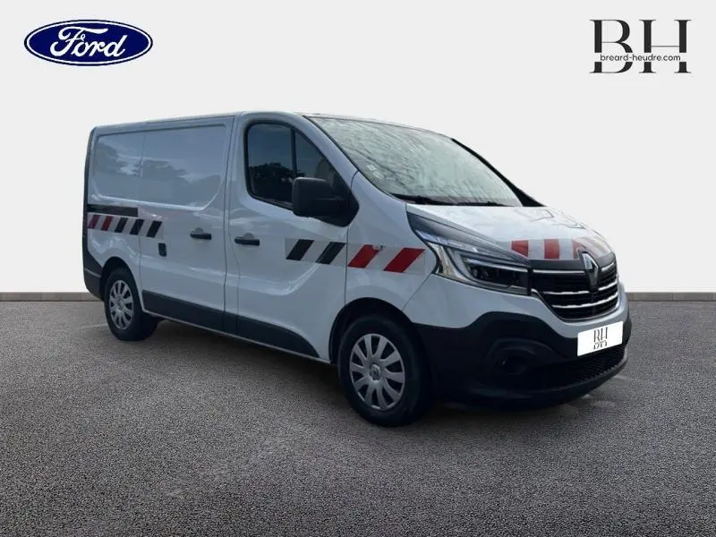 Renault Trafic Fourgon blanc glacier vu en 3/4 avant droit avec marquages rouges et noirs sur la carrosserie.