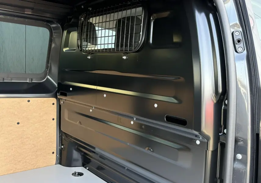 Vue intérieure arrière droite du Citroën Jumpy gris titane, montrant la cloison pleine vitrée et le plancher bois.
