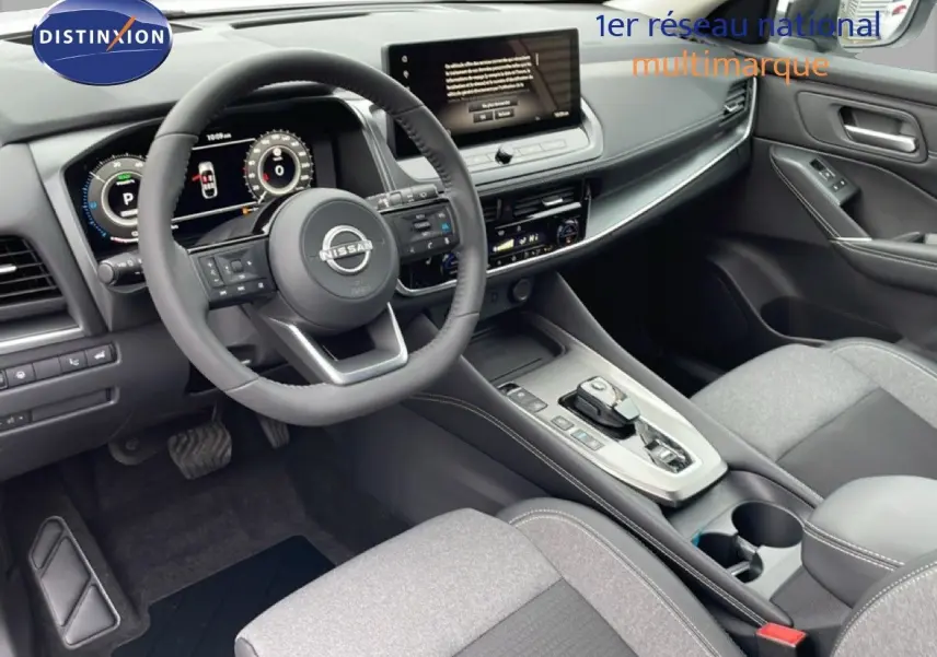 Vue intérieure côté conducteur du Nissan Qashqai blanc nacré 2025, mettant en valeur le tableau de bord digital et la console centrale moderne.