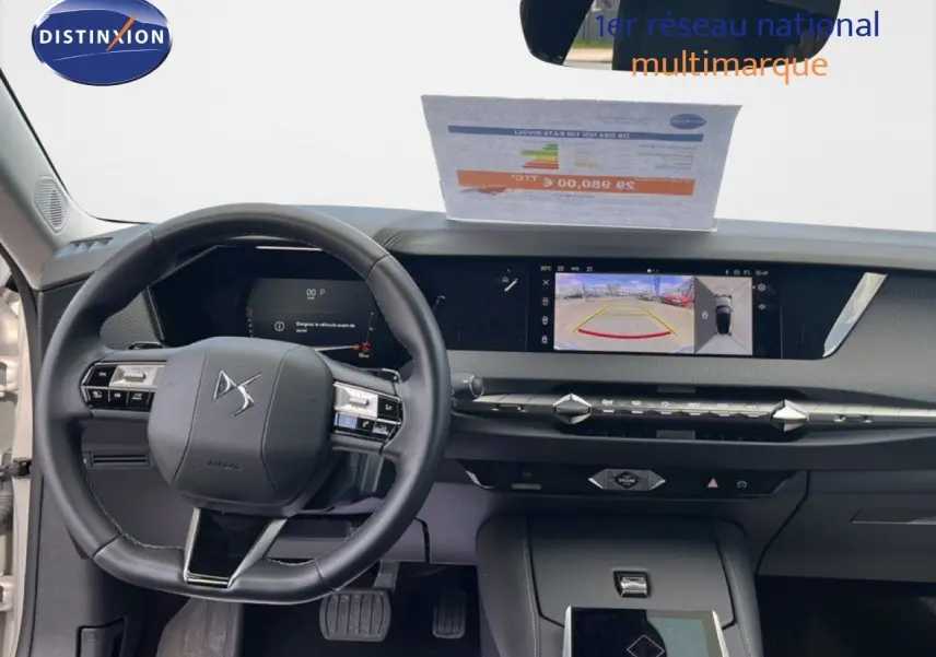 Vue intérieure avant du tableau de bord et volant noir du DS4 2024 avec écran tactile affichant la caméra de recul.