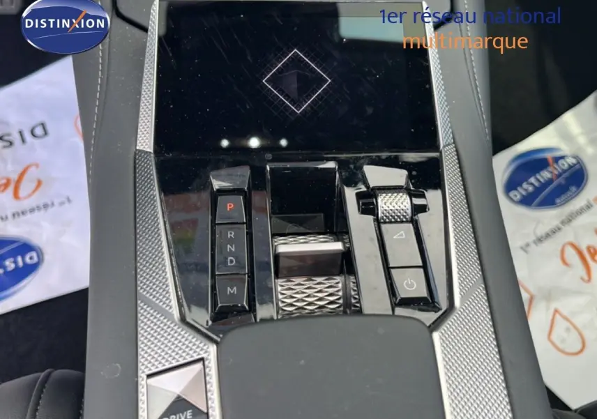 Vue rapprochée de la console centrale du DS4 2024, mettant en valeur la commande de boîte automatique et les finitions argentées texturées.